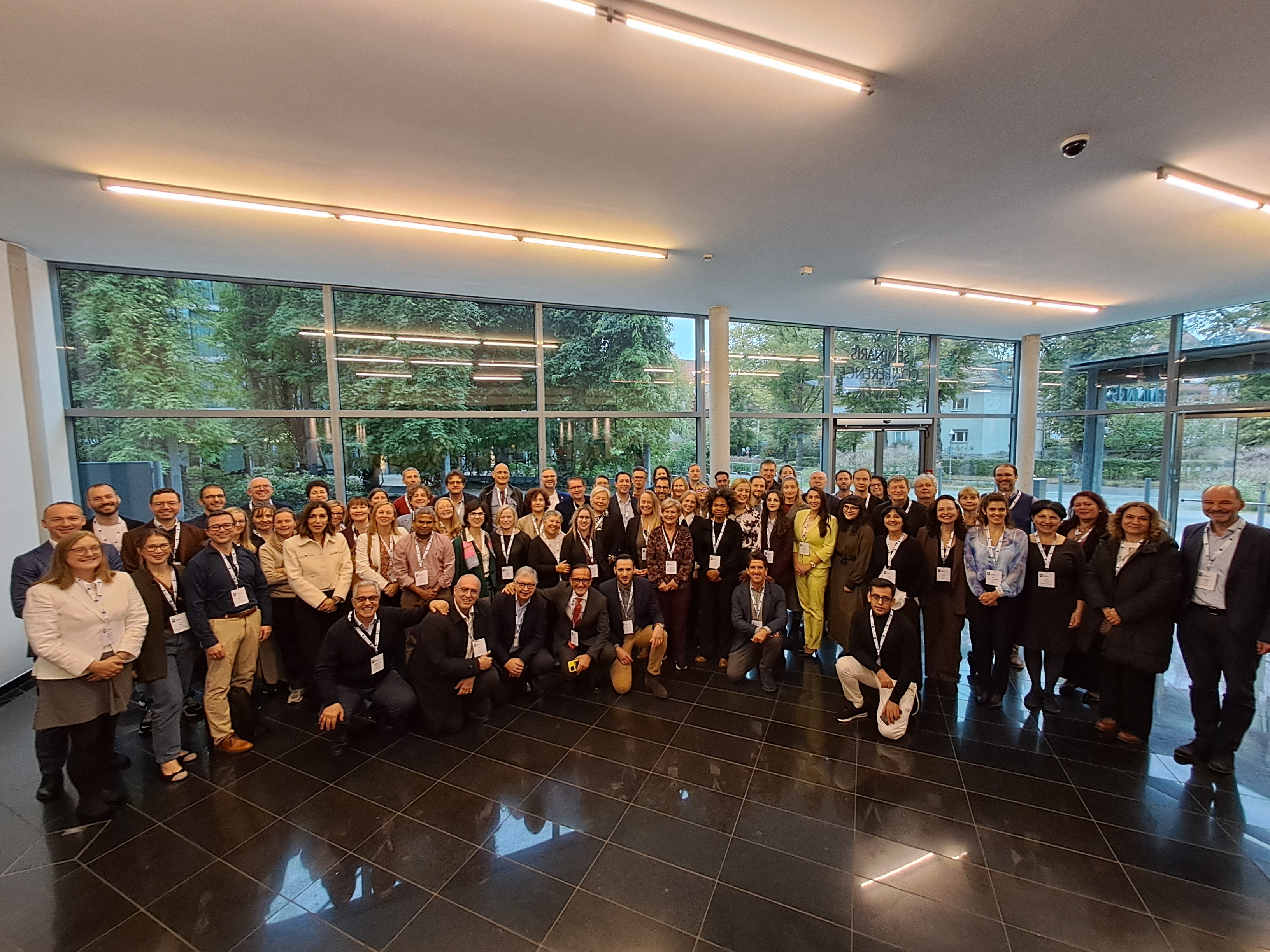 Group picture from above with a foyer and foliage in the background