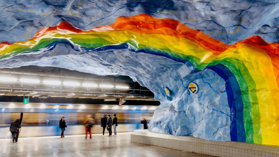 Underground tube station with a structured, rainbow-colored ceilling.
