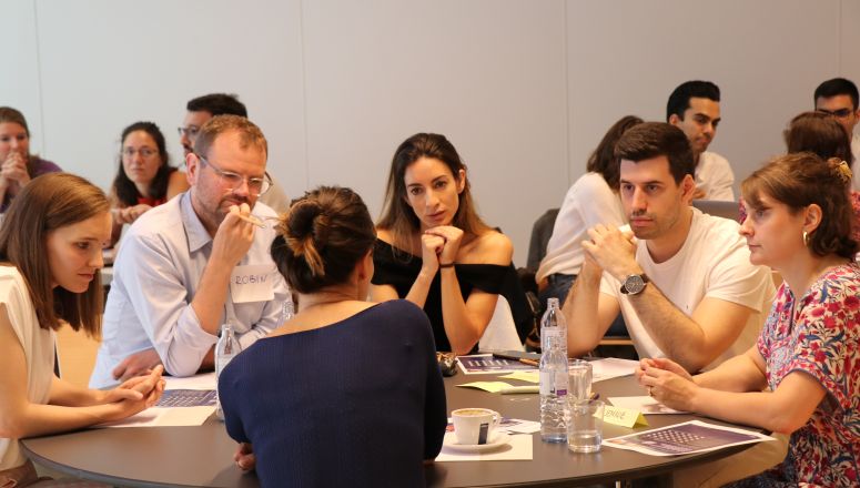 A group of people converses at a round table
