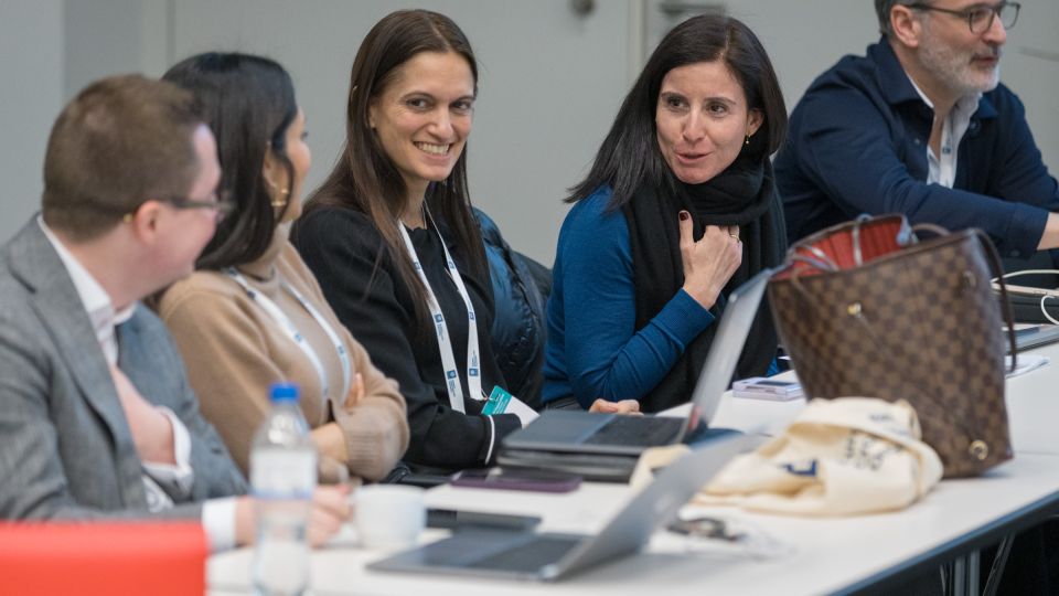 Five members of the operational board converse in a cheerful manner
